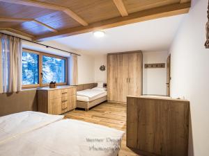 Schlafzimmer mit einem Bett, einem Schreibtisch und einem Fenster in der Unterkunft Piciulei Grant in Wolkenstein in Gröden