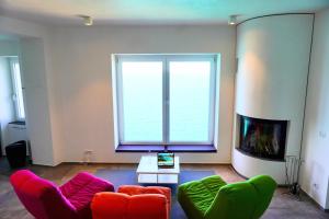 een woonkamer met rode en groene stoelen en een groot raam bij Colombo Suites in Peschici