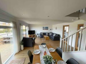 a living room with a table and a couch at Dunes View, waterside home with stunning views. in Bembridge