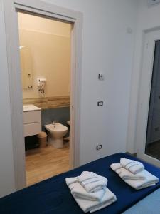 - une chambre avec un lit et 3 serviettes dans l'établissement Parco dei Gerani, à Formia