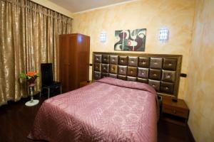 a bedroom with a bed with a red bedspread at Hotel Bengasi in Moncalieri