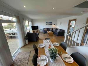 a dining table and chairs in a living room at Dunes View, waterside home with stunning views. in Bembridge