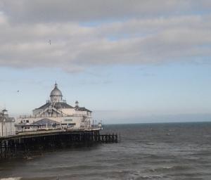 a pier with a building on it in the water at Sterling Lodge Hotel in Eastbourne