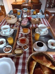 Chambre d'hôte Montlivault / Chambord في Montlivault: طاولة مع وجبة إفطار من الخبز والمشروبات