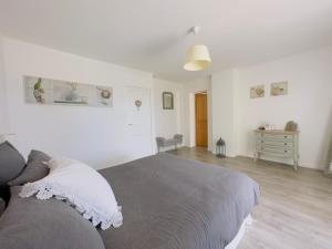 a white bedroom with a bed and a dresser at Gîte "Au Bord de l'Eau" in La Force