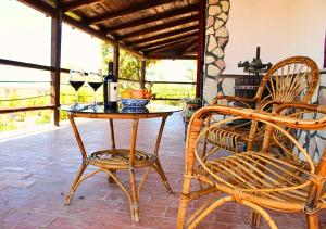 un patio con mesa, 2 sillas y copas de vino en Villa Finestra sul Castello, en Partinico