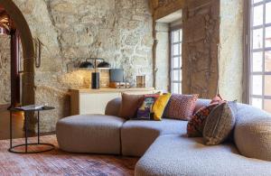 a living room with a couch and a stone wall at Hotel das Virtudes in Porto