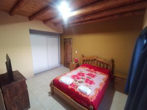 1 dormitorio con 1 cama con manta roja y blanca en Alquiler por día/semana en Luján de Cuyo