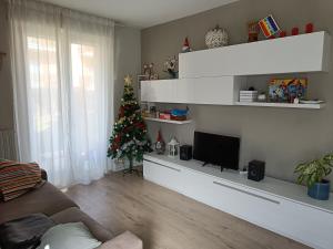 een woonkamer met een kerstboom en een bank bij Appartamento Tranquillo con Giardino in Morbegno