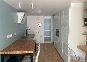 a small kitchen with a table and a refrigerator at Appartement duplex chaleureux pour 4 pers comprenant 1 lit double et 2 lits simples in Dammartin-en-Goële