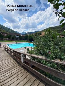 uma piscina num resort com um calçadão de madeira em Casa rústica en Dobres con vistas a la montaña em Dobres