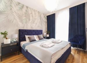 - une chambre avec un lit bleu et des serviettes dans l'établissement Danio Apart Old Town Gdańsk, à Gdańsk