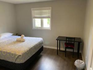a bedroom with a bed and a table and a window at Nice Rooms Stay - Unit 2 in Kingston