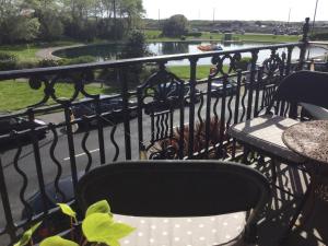 a balcony with a table and chairs and a view of a park at Arun Sands Rooms in Littlehampton