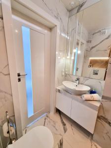 a white bathroom with a sink and a mirror at Baltic Soul Villa in Międzyzdroje