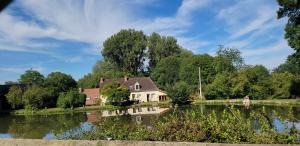 dom siedzący nad jeziorem w obiekcie Le moulin de Meslon w mieście Coust