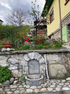 un muro in pietra con camino di fronte a una casa di Vila Venera a Velingrad