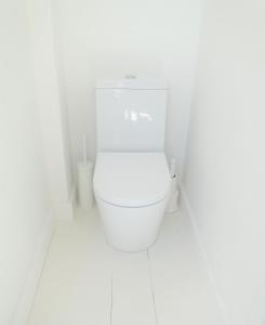 a bathroom with a white toilet in a white room at Cober House in Helston