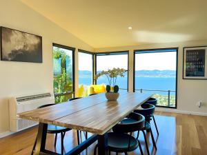 a dining room with a wooden table and chairs at Nicholas House - Luxury with river & city views in Sandy Bay