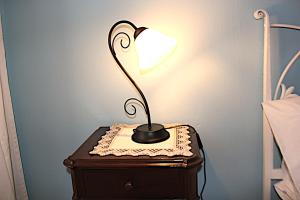 una lámpara sentada sobre una mesa junto a una cama en Art&Rusconi, en Como