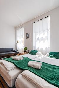 two large beds in a bedroom with green sheets at My city apartment - Vienna CityRoom in Vienna