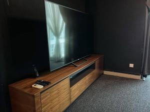 a large flat screen tv sitting on a wooden entertainment center at Large 2BR Near to Avisena, PKNS,SACC Mall,UitmSek7 Shah Alam in Shah Alam