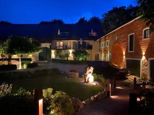 a house with a dog sitting in the yard at night at Gut Schwarz-n Hof Ferienwohnungen in Bad Griesbach