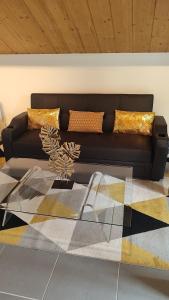 um sofá preto com almofadas douradas numa sala de estar em La maison blanche em Limoges