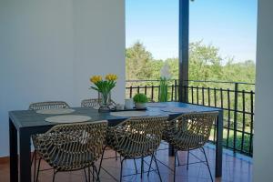 a dining table and chairs with a view of a balcony at Leon with Private Pool in Sveti Petar u Šumi