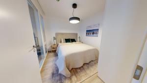 1 dormitorio con 1 cama en una habitación blanca en Näsijärvi lakeview apartment en Tampere