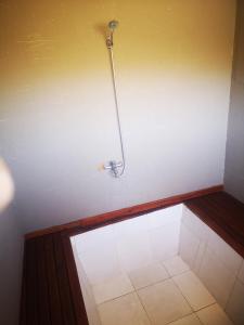 y baño con ducha y pared blanca. en Glamping Mendoza en Luján de Cuyo