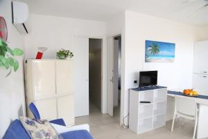 Appartamento bianco con sedia blu e scrivania. di Marchesana Beach sole mare spiaggia a Terme Vigliatore