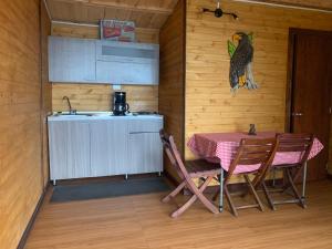 a kitchen with a table and chairs and a bird on the wall at Mirador Bosque Gran Torino Neusa in Cogua