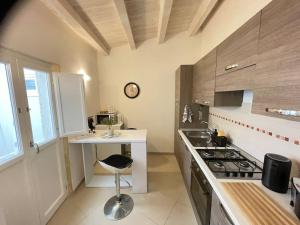 a kitchen with a counter and a table and a stove at Sunset Ortigia-locazione turistica in Syracuse