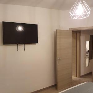 una camera da letto con TV a schermo piatto a parete di MERGELLINA APARTMENT a Napoli