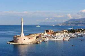 uma cidade com um farol no meio da água em Damilhouse 1 em Messina