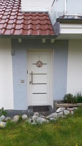 een wit huis met een witte deur en een rood dak bij Appartement Tischi in Ilsenburg