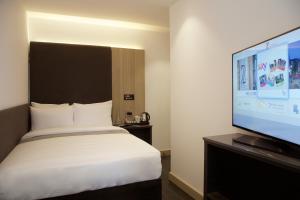 a bedroom with a bed and a flat screen tv at The Z Hotel Shoreditch in London