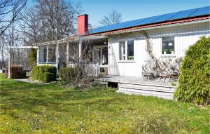 a white house with a porch and a yard at 2 Bedroom Awesome Home In Frjestaden in Färjestaden