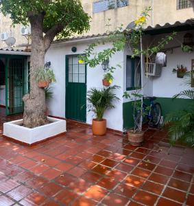 ein Haus mit einer grünen Tür und einem Baum in der Unterkunft La Casa de Taty in Valledupar