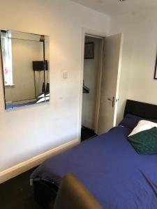 1 dormitorio con cama y espejo en la pared en The Whitehouse, en Londres