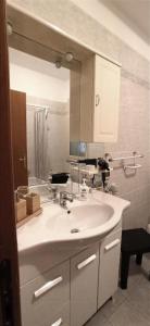 een badkamer met een witte wastafel en een spiegel bij Contessa Vacanze Byron in Contessa Entellina