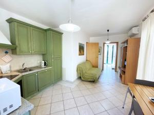 une cuisine avec des armoires vertes et une chaise verte dans l'établissement La Casina di Grassera - Argonauti Vacanze, à Rio nellʼElba
