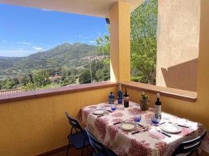 una mesa con platos y botellas de vino en el balcón en La Casina di Grassera, en Rio nellʼElba