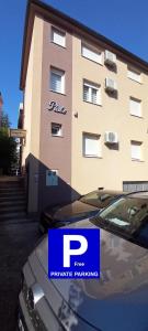 a car parked in front of a large building at Apartments Platz in Mostar