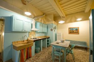 eine Küche mit blauen Schränken, einem Waschbecken und einem Tisch in der Unterkunft Casa vacanze Fatucchi in Foiano della Chiana