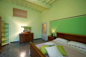 Schlafzimmer mit einem Bett, einer Kommode und einem Spiegel in der Unterkunft Casa vacanze Fatucchi in Foiano della Chiana