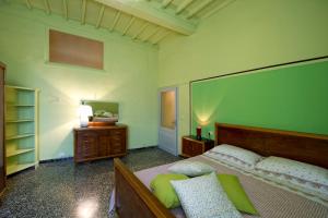 a bedroom with a bed and a dresser and a mirror at Casa vacanze Fatucchi in Foiano della Chiana