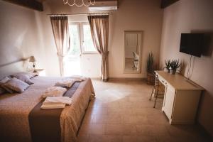 a bedroom with a bed and a desk and a window at IL FILARO del Castello di San Basilio in Pisticci