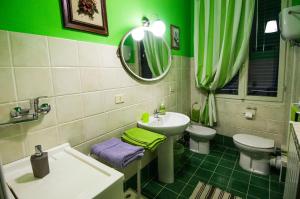 ein grünes Bad mit einem Waschbecken und einem WC in der Unterkunft Casa vacanze Fatucchi in Foiano della Chiana